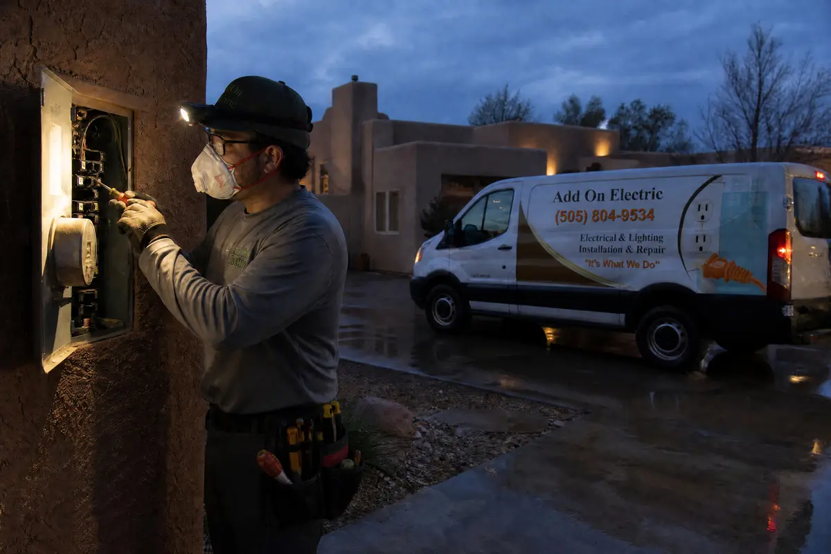 Electrician on an evening service call at an outdoor panel